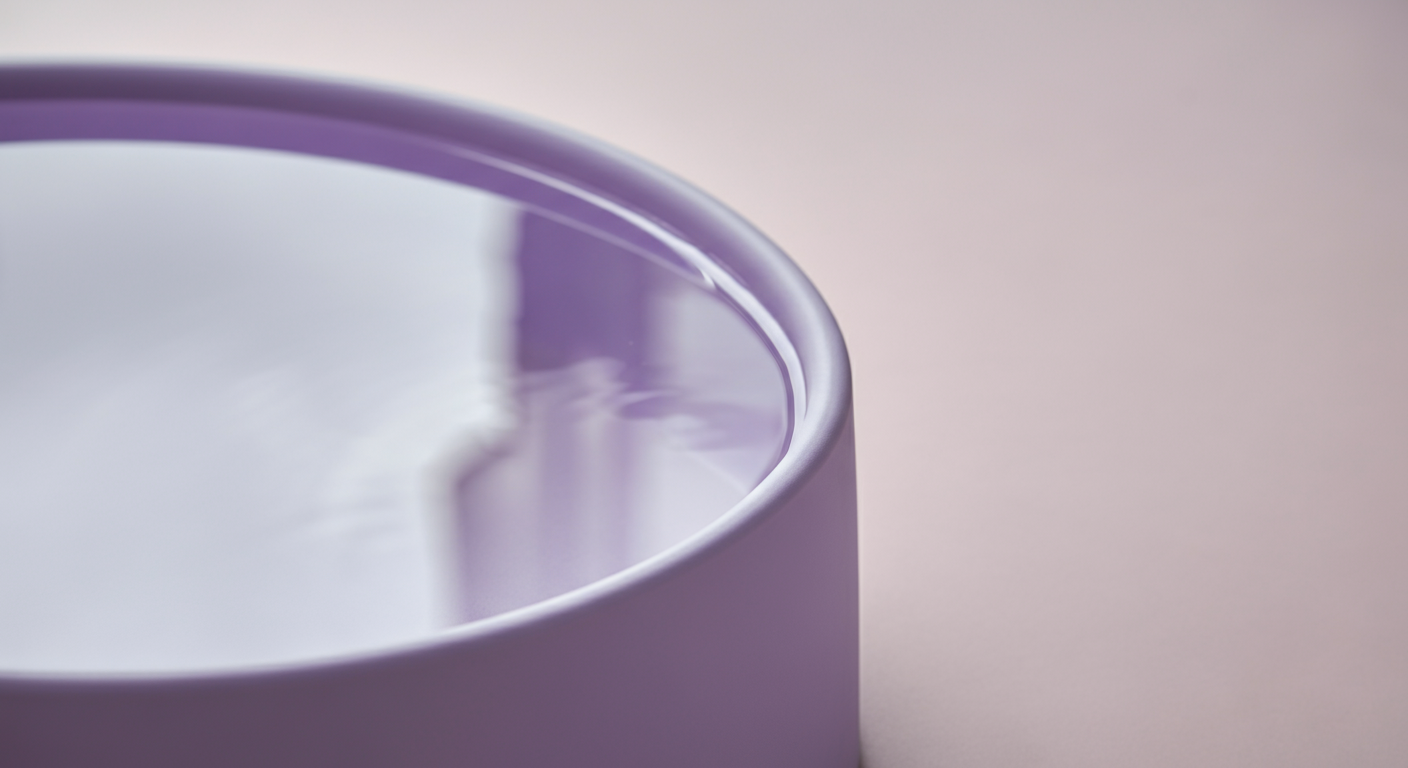 水面に犬の頭の形が抽象的に反射している、幅の広いライラック色の水飲みボウル